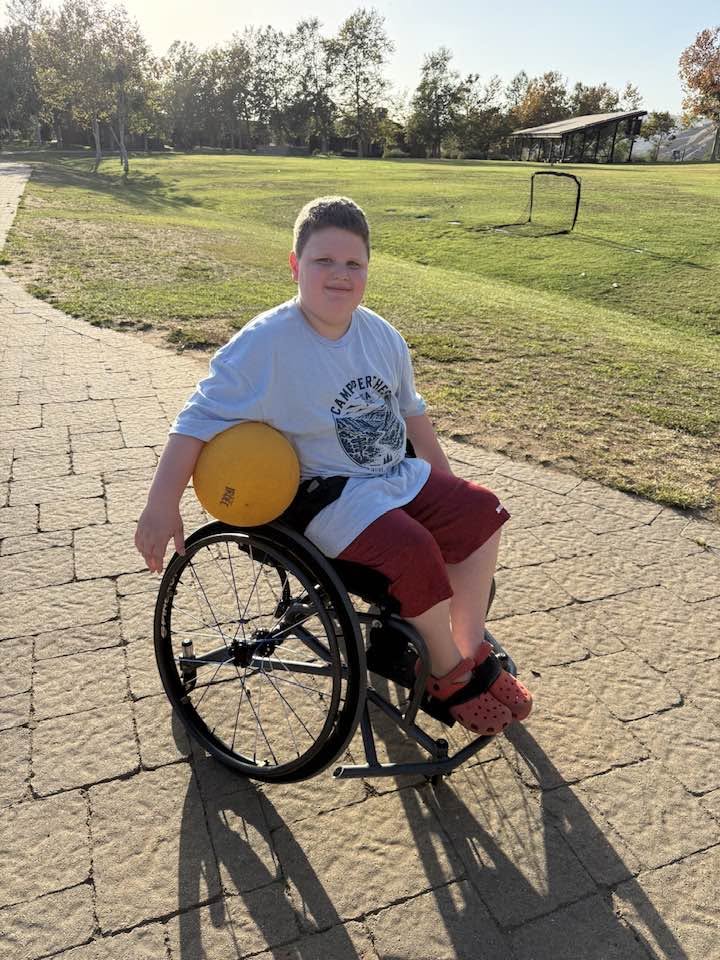 A camper who uses a wheelchair playing a game at camp