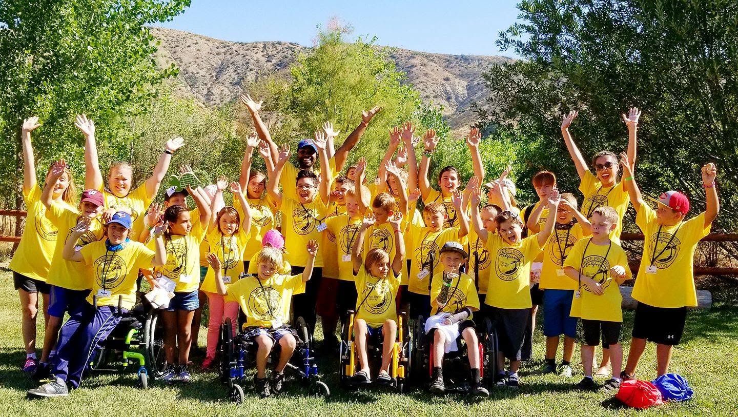 Camp Perthes campers and volunteers cheering with hands raised